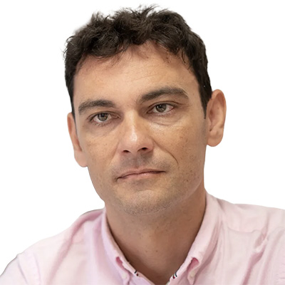 Retrato de Manuel Pavon con fondo blanco y camisa rosa