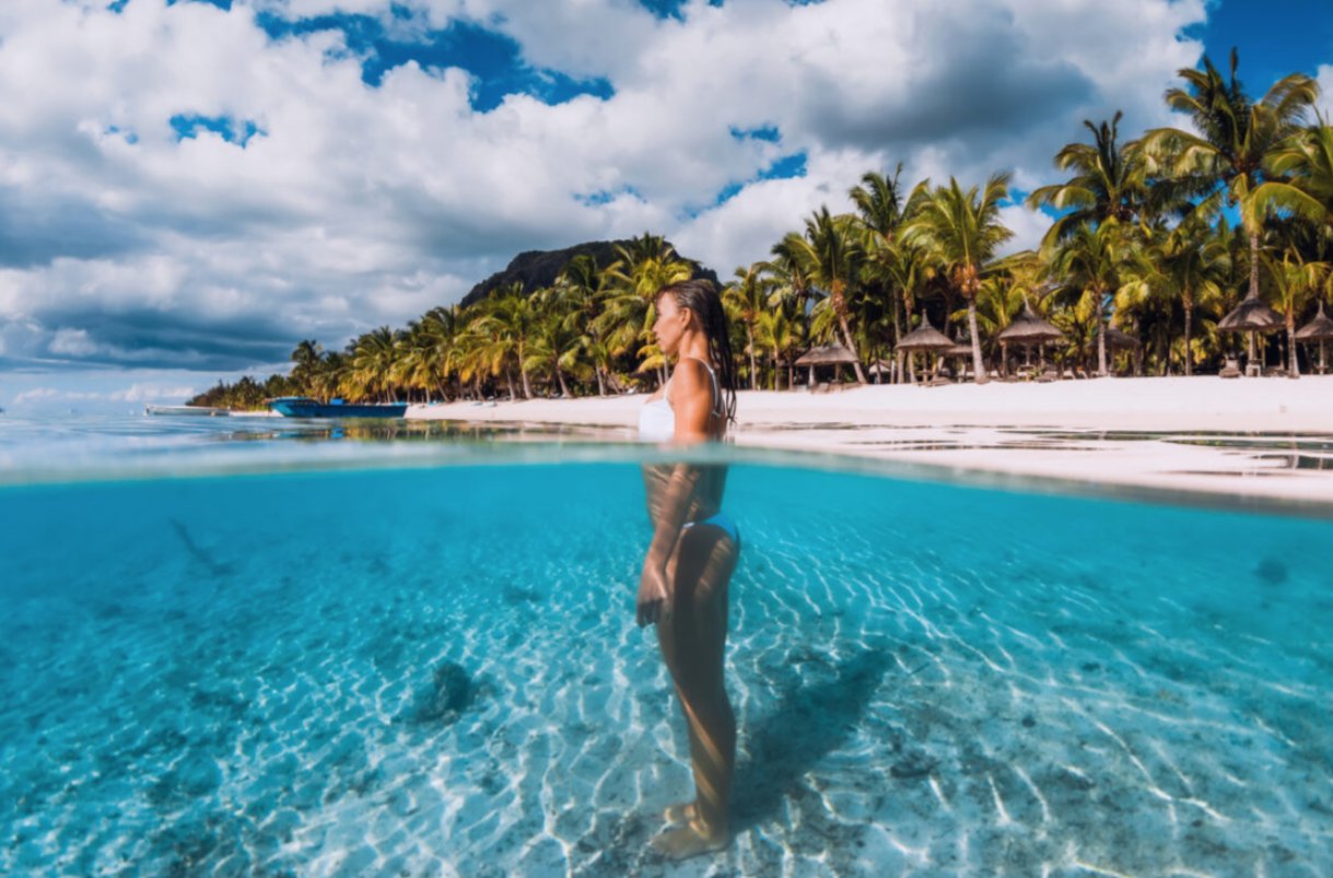 Mujer de pie en aguas cristalinas de una playa en Mauricio