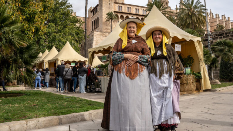 Dos mujeres vestidas con trajes tradicionales en el Mercado del Día de Baleares
