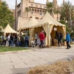 Puestos del mercado en el D&iacute;a de les Illes Balears con gente y palmeras