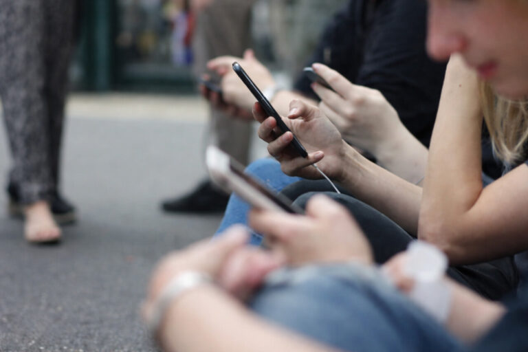 Jóvenes utilizando sus teléfonos móviles en un entorno urbano