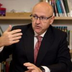 Hombre hablando sobre el control de precios de alquiler en una reuni&oacute;n