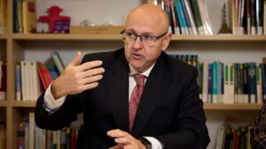 Hombre hablando sobre el control de precios de alquiler en una reuni&oacute;n