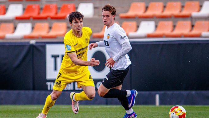 Jugadores de Poblense y ATB compitiendo en el campo de fútbol