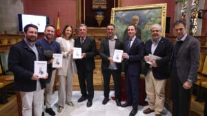 Grupo de personas sosteniendo libros en un evento cultural sobre Joan Alcover