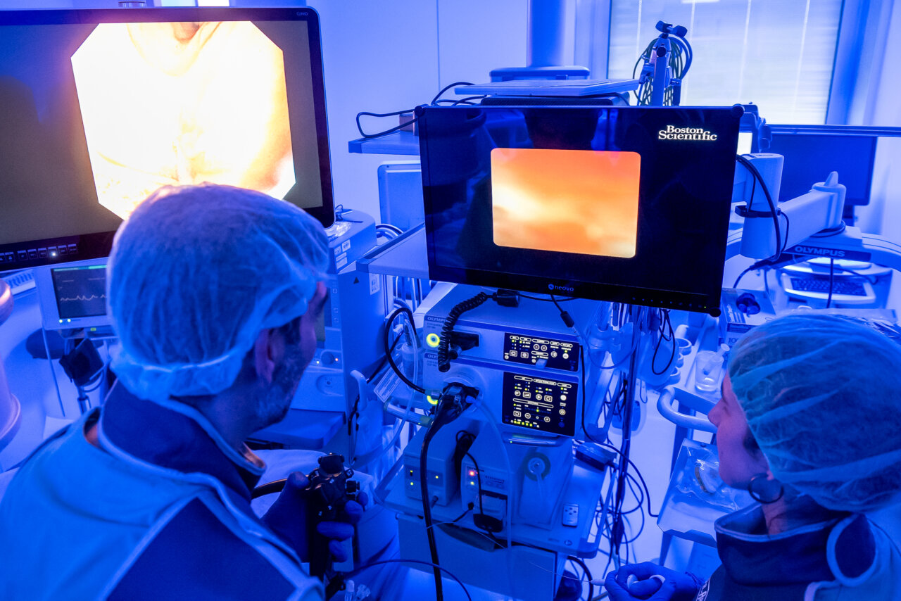 M&eacute;dicos realizando un procedimiento de endoscopia con monitores y equipos m&eacute;dicos
