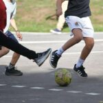 Ni&ntilde;os jugando al f&uacute;tbol en un patio escolar inclusivo