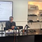 Rueda de prensa de API con presentador y micr&oacute;fonos en la mesa.