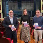 Tres personas sosteniendo folletos en el Teatre Principal