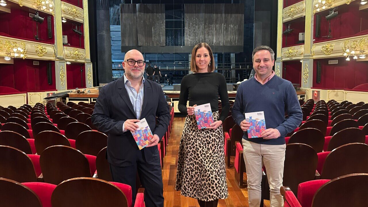 Tres personas sosteniendo folletos en el Teatre Principal