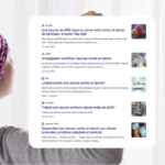 Persona con pa&ntilde;uelo en la cabeza mirando titulares sobre c&aacute;ncer