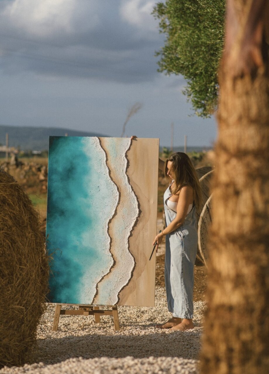 Victoria Canals mostrando su obra de arte inspirada en las olas del mar