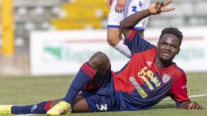Zito Luvumbo posando en el campo de f&uacute;tbol con camiseta del Cagliari