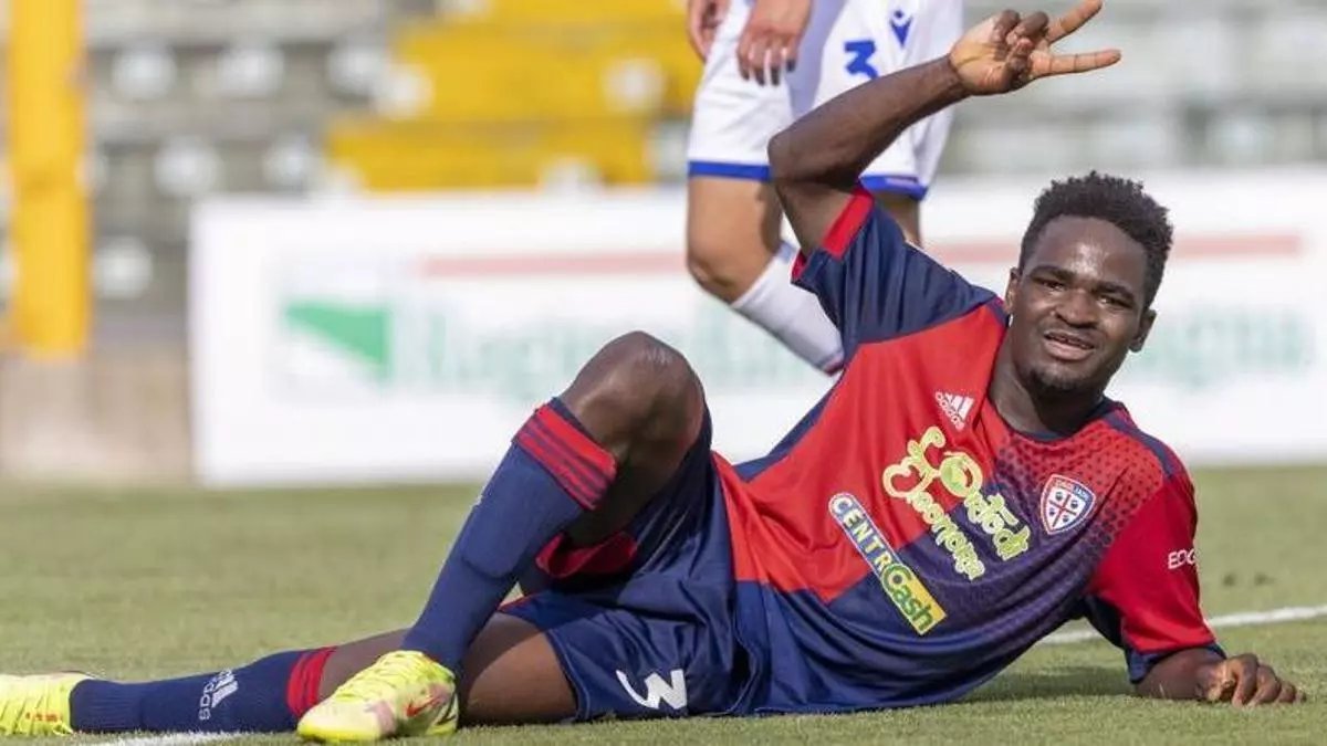 Zito Luvumbo posando en el campo de f&uacute;tbol con camiseta del Cagliari