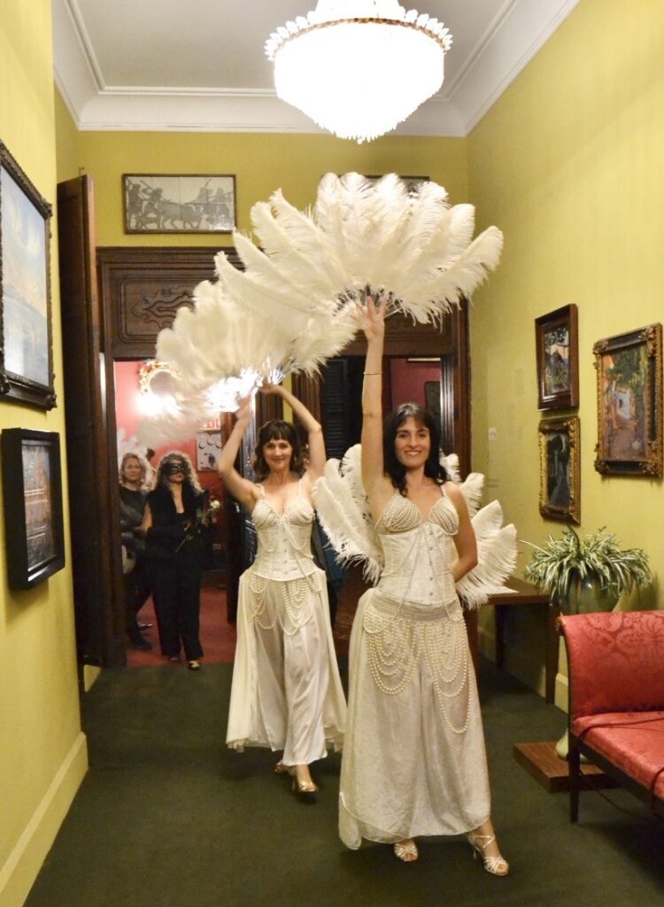 Actrices en vestuario de burlesque con plumas en un evento en Mallorca