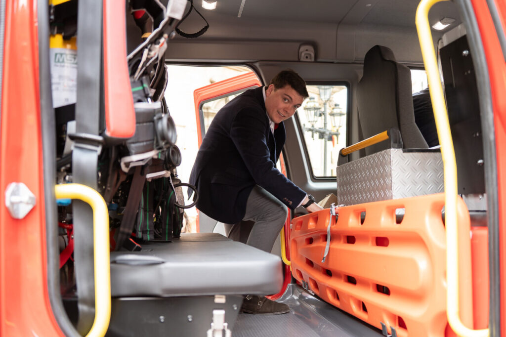 Interior de un cami&oacute;n de bomberos con un hombre organizando equipo