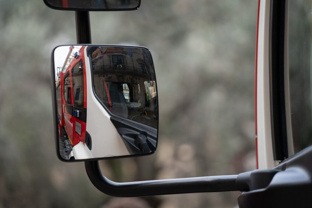 Reflejo de un cami&oacute;n de bomberos en el espejo retrovisor