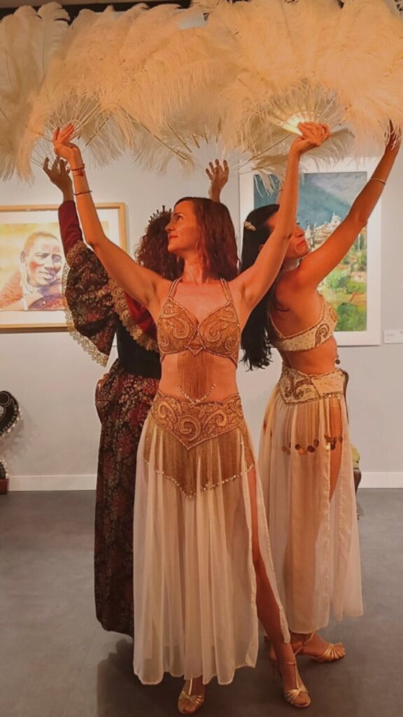 Tres bailarinas con plumas en un evento de danza y teatro