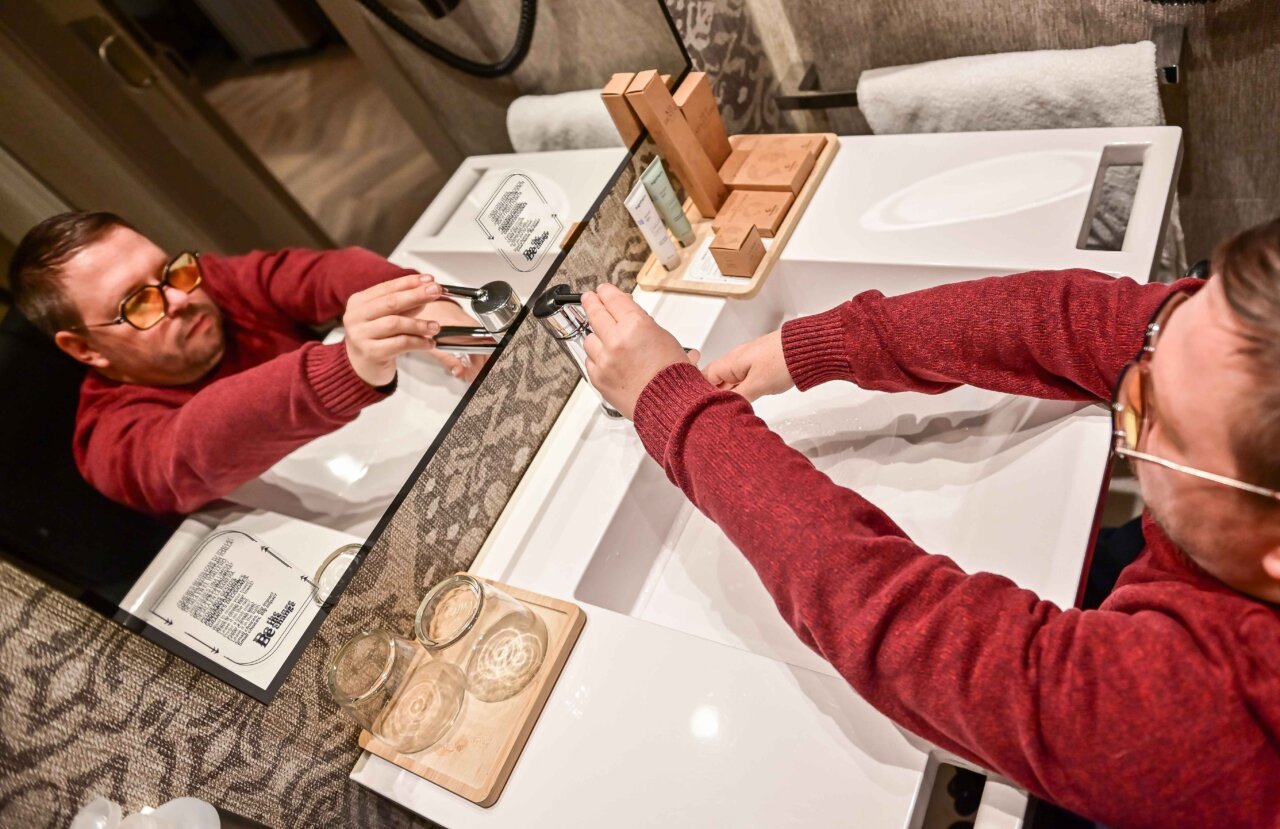 Persona utilizando lavabo en un ba&ntilde;o accesible en un hotel