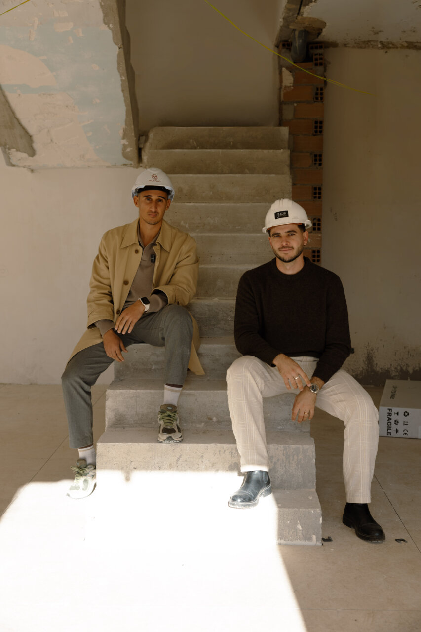Dos j&oacute;venes ingenieros sentados en escaleras de una obra en Mallorca