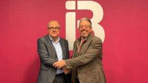 Dos hombres estrechando manos en un evento de firma de convenio