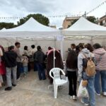 Vista de un mercado al aire libre con varios puestos y visitantes en Andratx