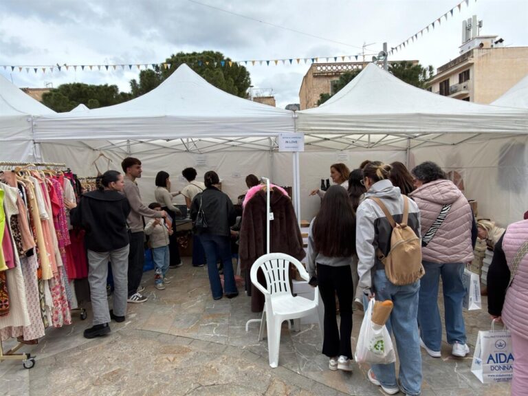 Vista de un mercado al aire libre con varios puestos y visitantes en Andratx