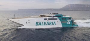 Ferry de Bale&agrave;ria navegando en el mar con monta&ntilde;as al fondo
