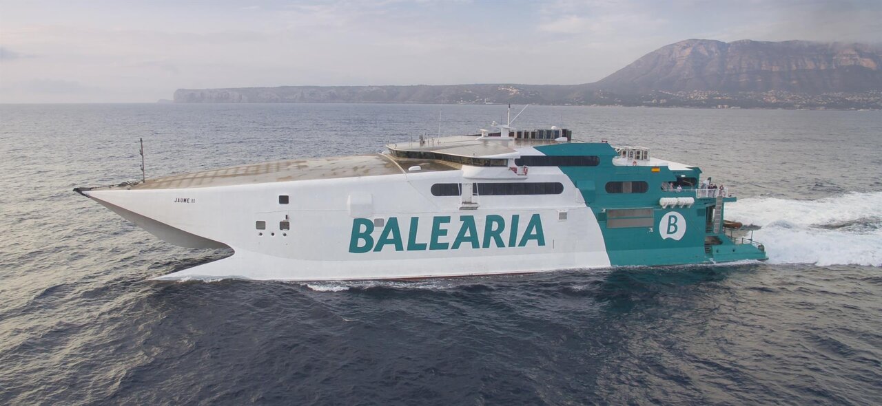 Ferry de Bale&agrave;ria navegando en el mar con monta&ntilde;as al fondo