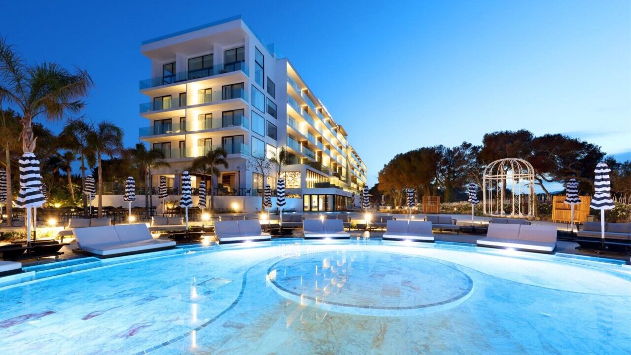 Vista del Bless Hotel Ibiza con piscina iluminada de noche