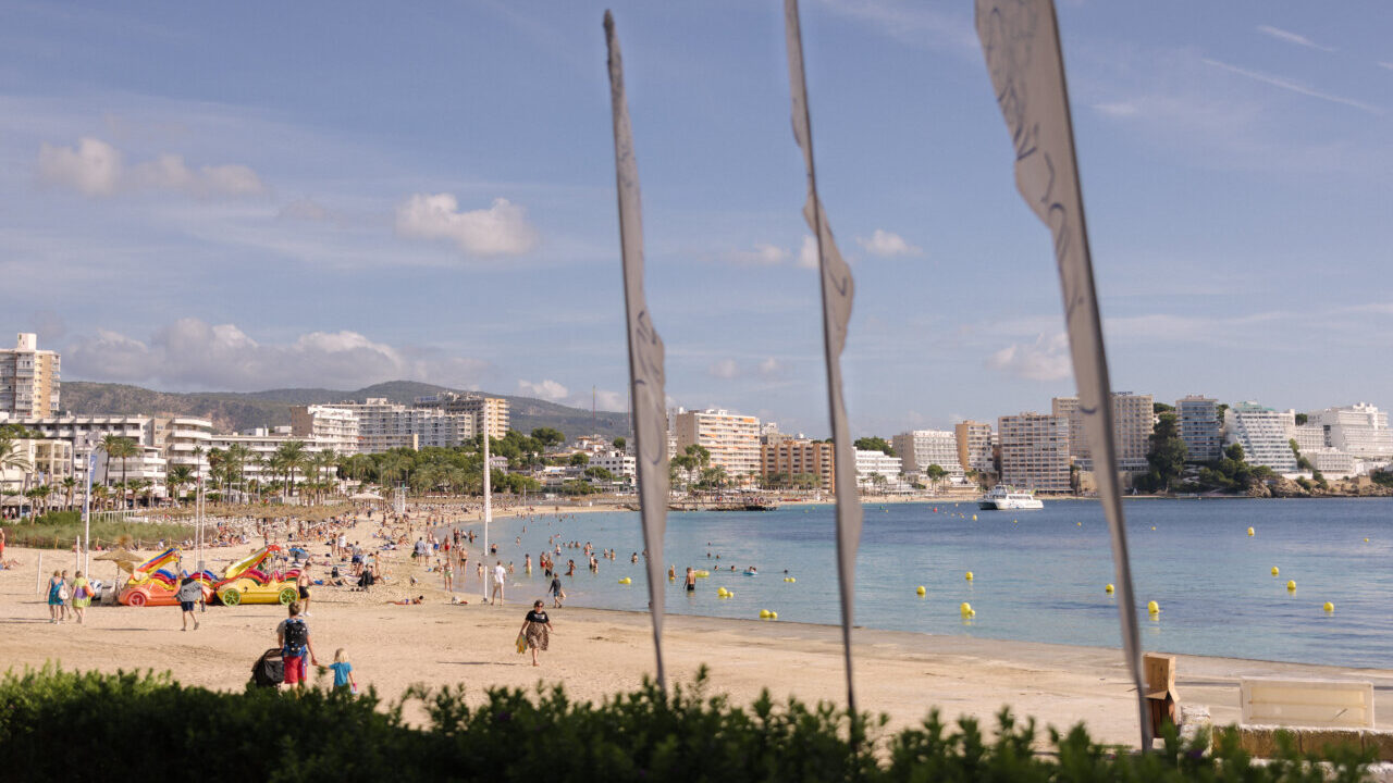 Vista de la playa en Calvi&agrave; con turistas disfrutando del sol.