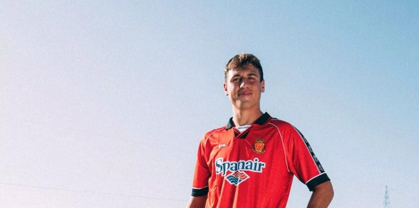 Jugador del RCD Mallorca vistiendo camiseta retro en un fondo azul