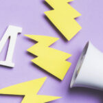 Meg&aacute;fono y letras 8M sobre fondo morado, simbolizando la lucha por la igualdad de g&eacute;nero.