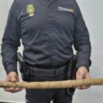 Policía Nacional mostrando un palo utilizado en una amenaza
