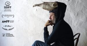 Retrato de Miquel Adrover con un sombrero peculiar en un fondo claro