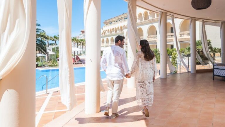 Pareja caminando hacia la piscina en un hotel Pure Salt en Mallorca