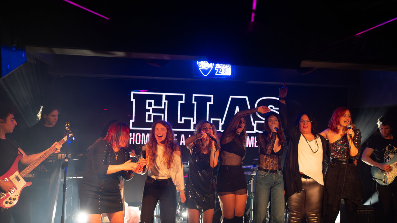 Mujeres cantando en un escenario durante el evento Ellas Homenaje
