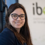 Marta Pons sonriendo en un entorno profesional con persianas azules