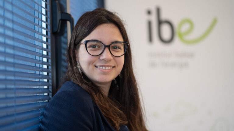 Marta Pons sonriendo en un entorno profesional con persianas azules