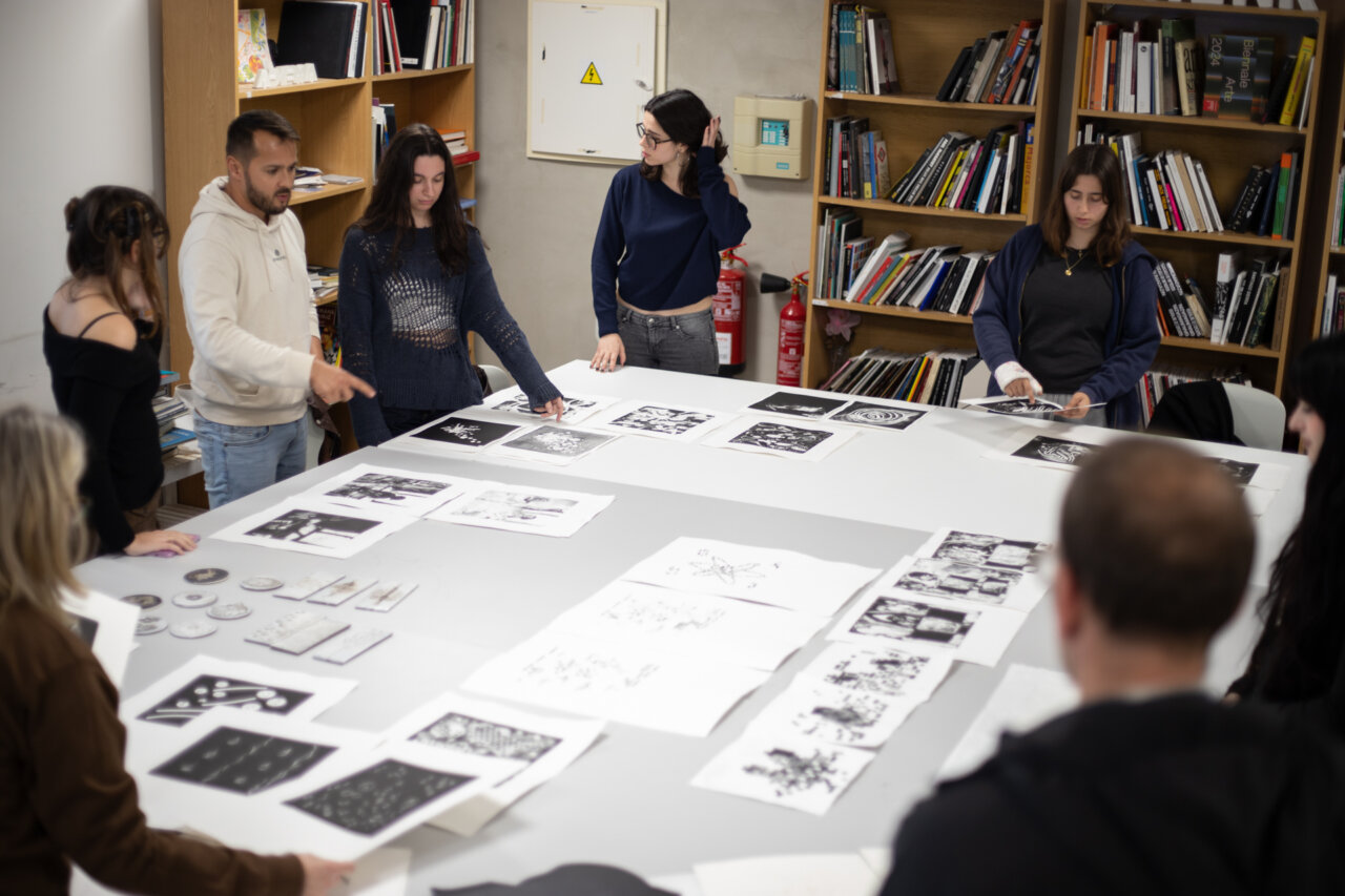Estudiantes de Adema discutiendo obras en una mesa de trabajo