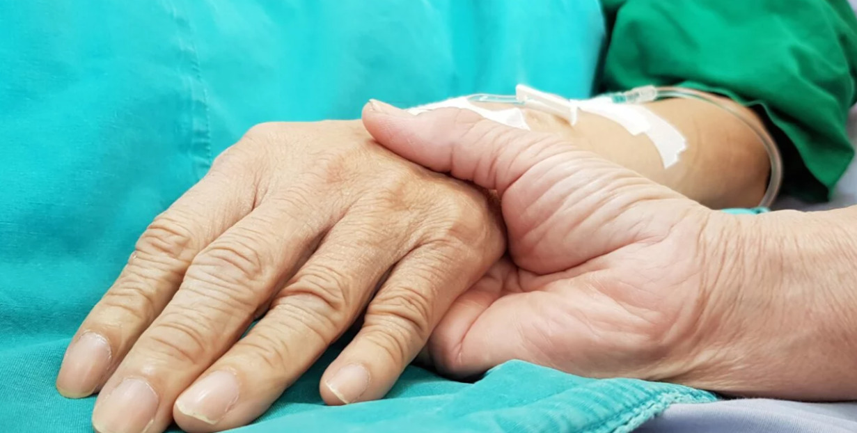 Manos entrelazadas en un contexto de atenci&oacute;n m&eacute;dica