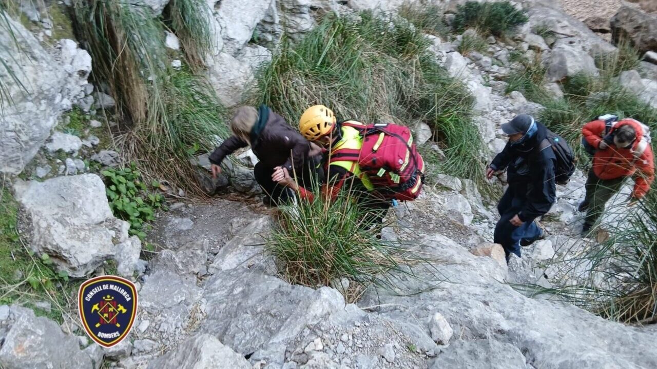 Bomberos evacuando a un menor en el Torrent de Pareis