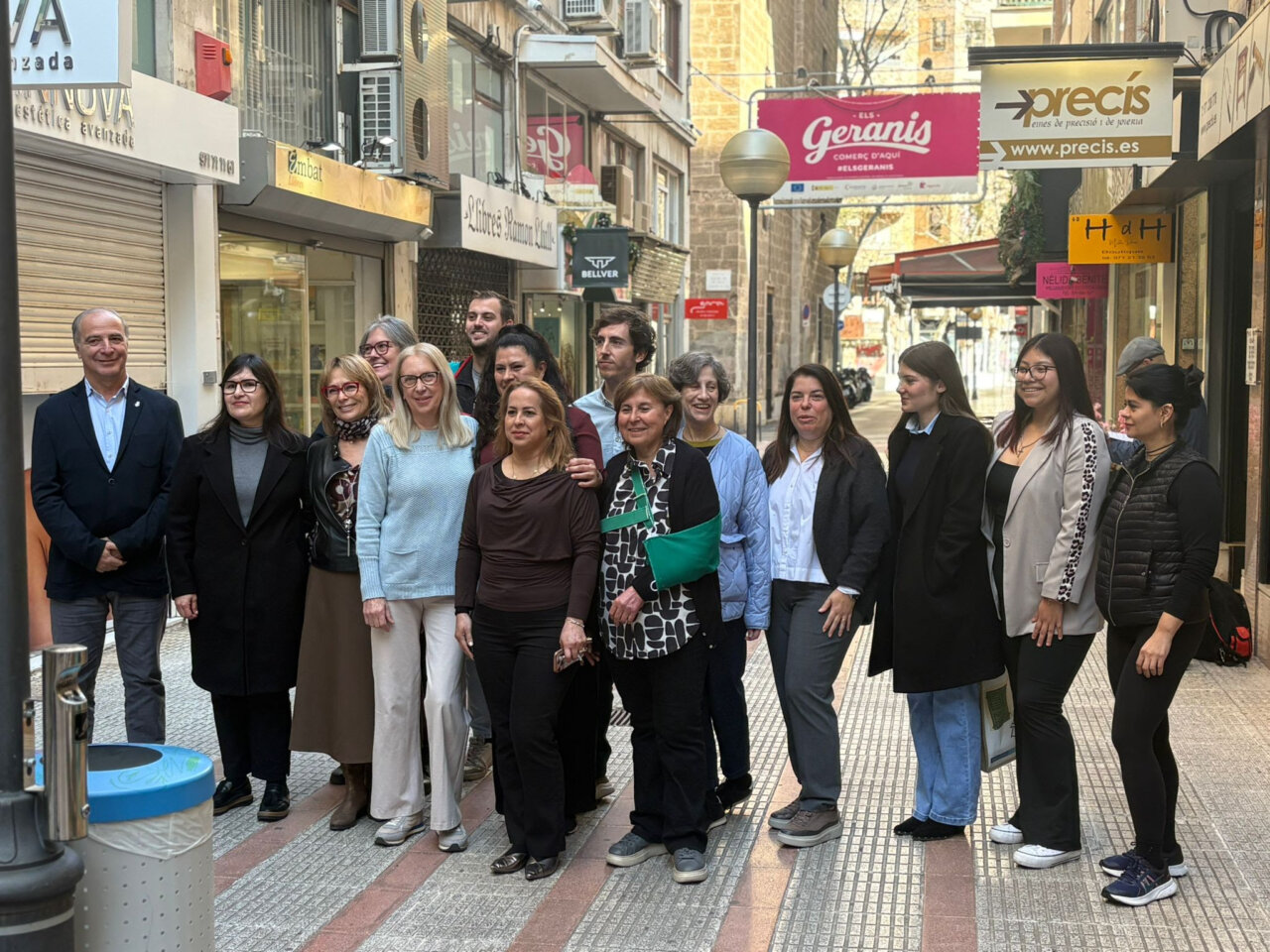 Grupo de personas en la Feria de Estocs en Palma, con comercios de fondo.