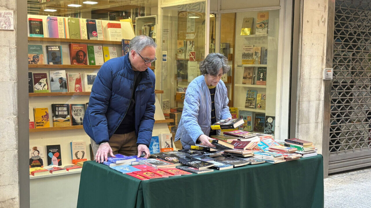 Dos personas organizando libros en una mesa durante la Feria de Estocs en Palma.