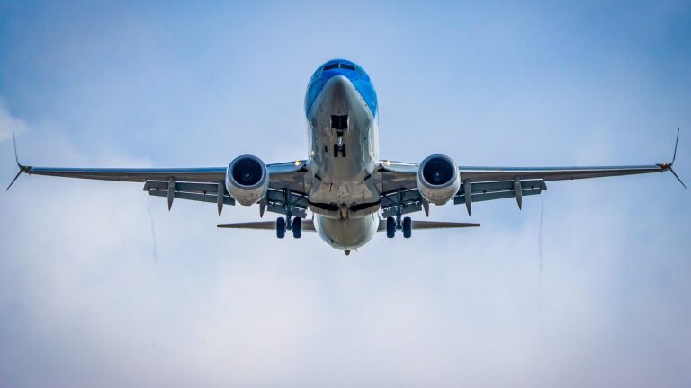 Avi&oacute;n volando en el cielo con nubes de fondo