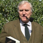 Hombre con pipa sosteniendo un libro titulado Historia