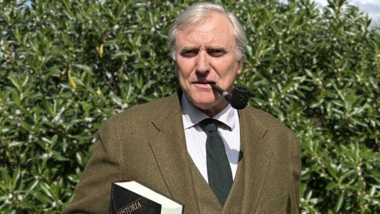 Hombre con pipa sosteniendo un libro titulado Historia