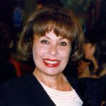 Gemma Cuervo sonriendo en un evento, con cabello corto y labios rojos.