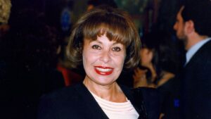 Gemma Cuervo sonriendo en un evento, con cabello corto y labios rojos.
