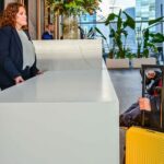 Recepción de hotel con una mujer y un hombre en silla de ruedas.